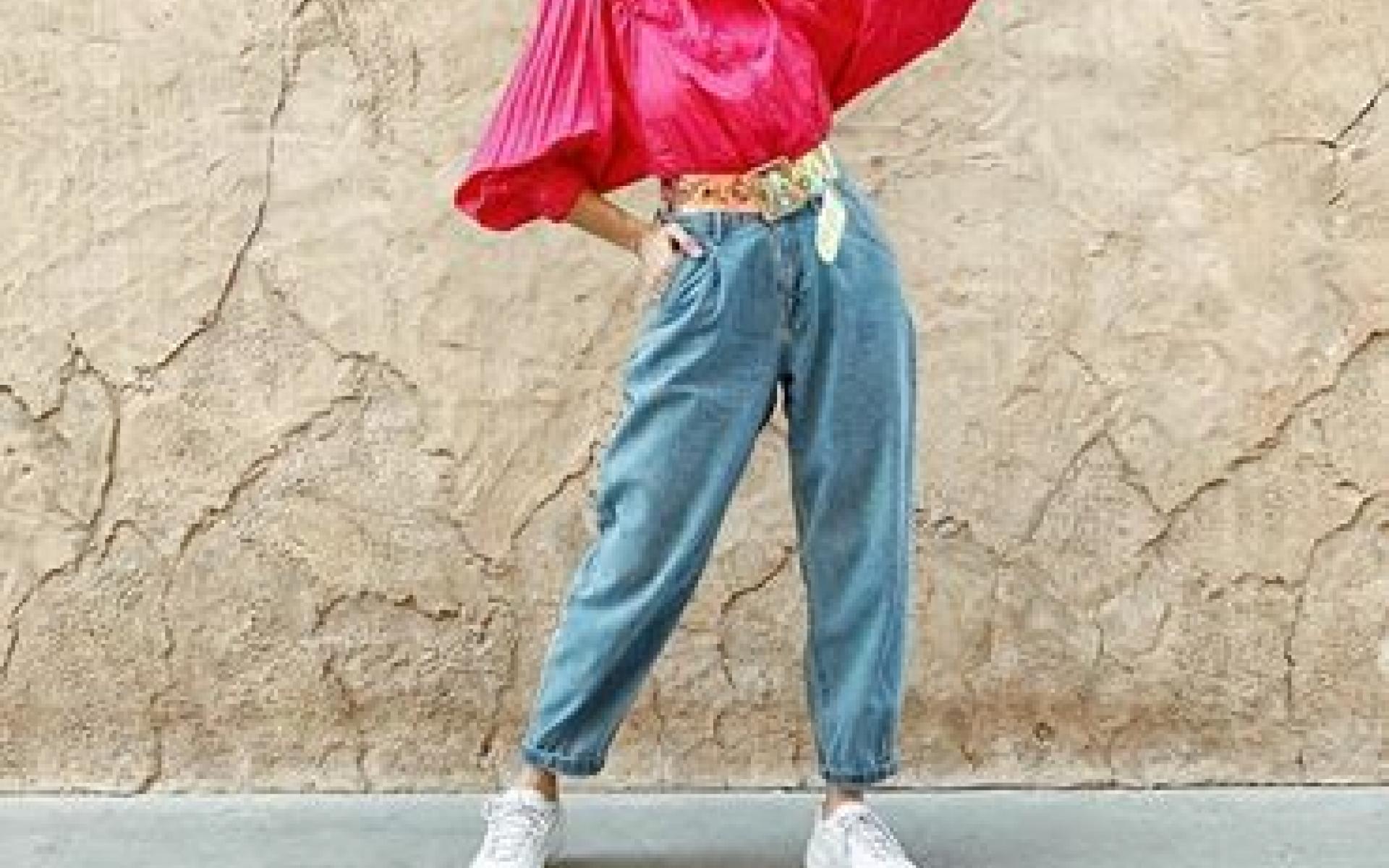 نسقت العارضة بنطلون مام فيت أزرق وتوب واسع باللون الفوشيا وحزام لامع، وأختارت حذاء أبيض رياضي. تعد إطلالة أنيقة وبسيطة تناسب خروجات مع الأصدقاء.