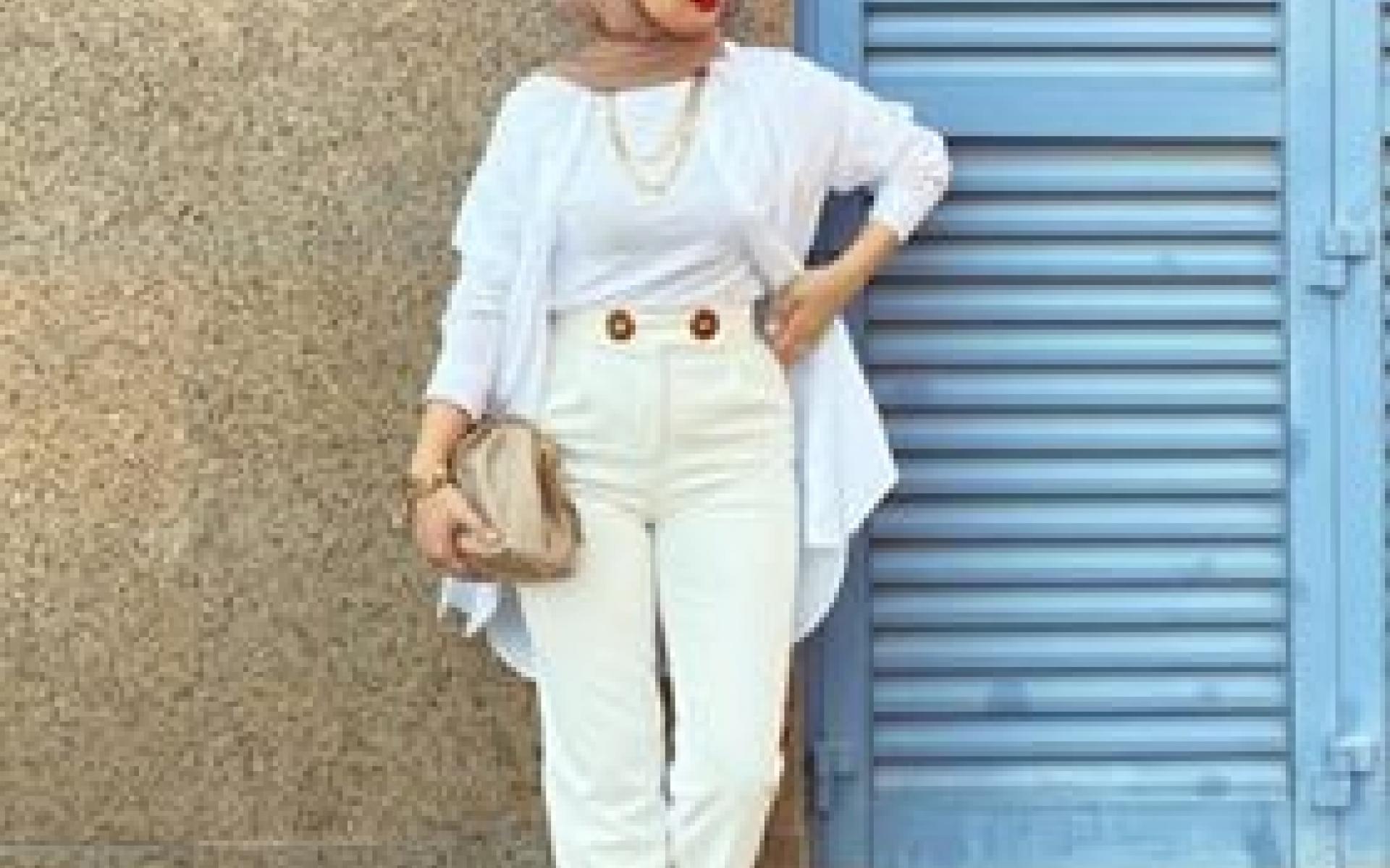 اختارت العارضة بنطلون مام فيت باللون الأبيض ونسقت معه توب أبيض وقميص طويل باللون الأبيض، وزينت الإطلالة بحجاب وحقيبة وحذاء باللون البيج، واضافت قطعة من الإكسسوار الذهبي وبدت في غاية الروعة. يمكنك إعتماد هذه الإطلالة في خروجة صباحية وأيضاً خروجة مسائية .