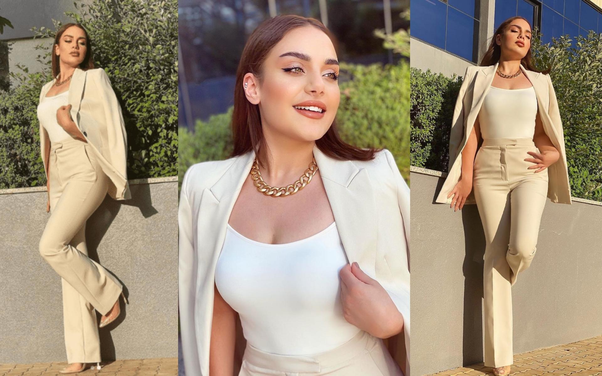 إطلالة رسمية ببدلة باللون النود وتوب باللون الأبيض وعقد ذهبي على شكل سلسلة