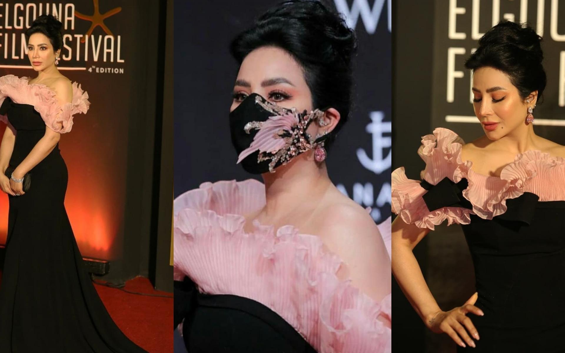 خطفت لجين عمران الأنظار من مهرجان الجونة بفستان أسود كلاسيكي طويل ميزه التصميم عند منطقة الصدر والكمامة المستوحاة من نفس الفستان